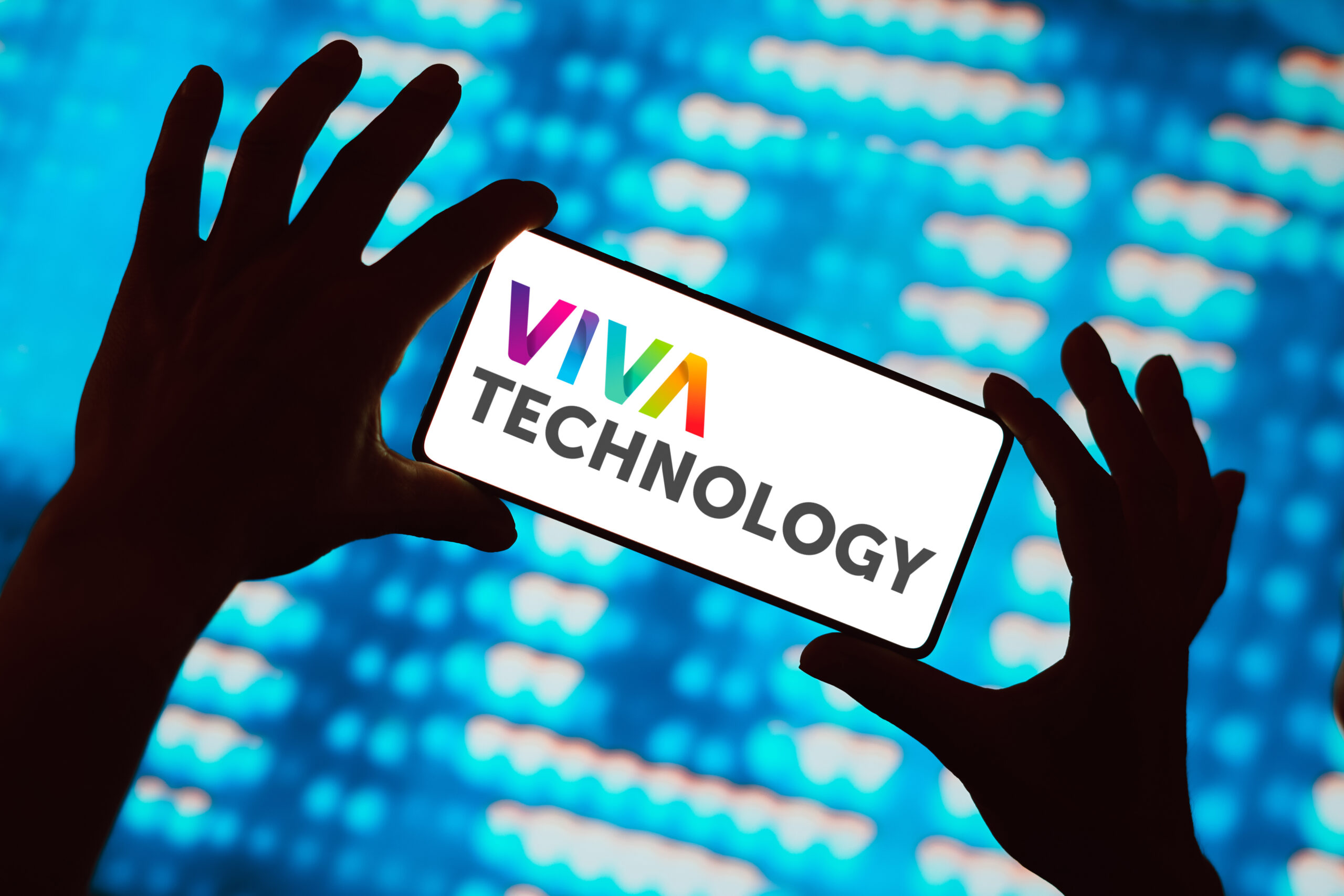Hände halten ein Handy mit Viva Technology Schriftzug